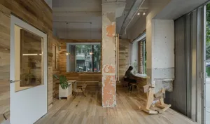 A café interior featuring industrial design elements with wooden elements and exposed brick walls.