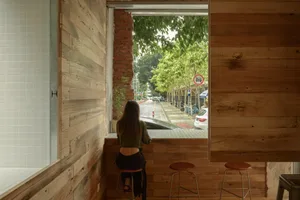 A modern design featuring window seating in a coffee shop with wood and brick materials.
