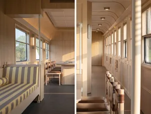 Modern, spacious railway carriage featuring wood paneling and seating arrangements.