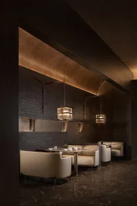 Modern restaurant interior with wooden walls, contemporary furniture, and ambient lighting.