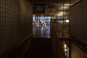 A modern restaurant interior with wooden elements and warm lighting.