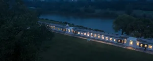 A modern train with a sleek design and illuminated windows.
