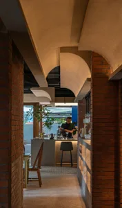 A cafe bar with exposed brick walls, concrete ceiling, and industrial design elements.