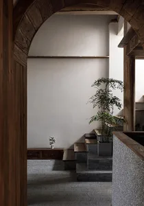 An industrial-style interior space featuring concrete walls and wooden arches.