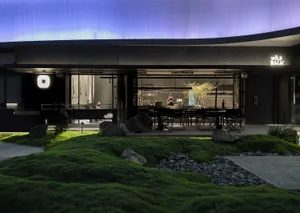 Contemporary restaurant exterior with concrete pavement, grass, and a modern design.