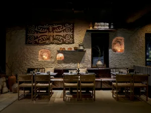 Industrial design restaurant interior with concrete walls and illuminated nooks.