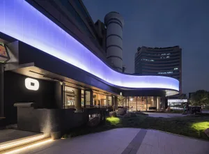 A minimalist retail storefront featuring concrete elements at night.
