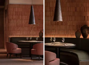 A modern industrial restaurant interior featuring a wooden dining table and chairs, with a dark, textured pendant light hangi