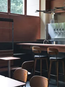 Modern restaurant bar with wooden furniture and a bar counter.