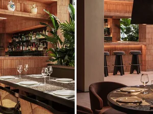 A modern restaurant bar featuring wooden interiors and a well-stocked bar.