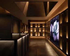 A modern business hotel suite featuring sleek metal railings, glass surfaces, and illuminated LED panels.