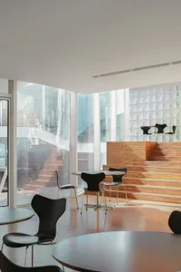 Modern café interior featuring glass, wood, and concrete materials.