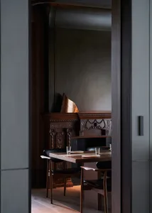A modern dining room featuring wooden furniture and black leather chairs.