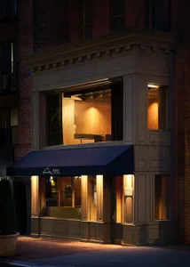 Modern storefront with brick facade, glass doors, and wooden accents.