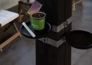 A modern coffee shop with a black metal railing and seating area.