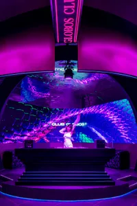 A vibrant nightclub venue featuring a digital light installation with a lizard skin pattern and the text 'CLUB GLOBOS'.