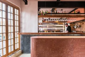 Industrial-style restaurant with wooden accents and a terrazzo countertop.