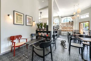 Interior of a minimalist coffee shop with concrete flooring and seating.