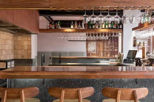 A modern restaurant featuring industrial-style wooden and terrazzo surfaces.