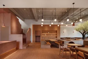 Modern restaurant interior with brick walls and concrete ceiling