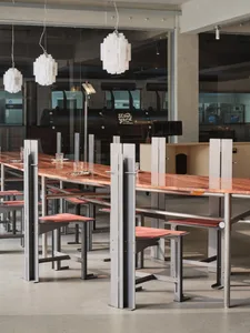 Industrial-style restaurant interior with metal tables and wooden counter.