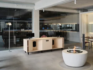Modern barbecue restaurant with concrete flooring, wooden furniture, and glass walls.