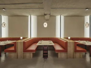 Modern restaurant interior with booth seating made of leather on concrete floor