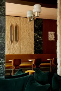 Luxurious industrial-style cafe with plush velvet seating and marble walls.