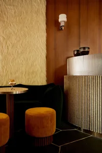 Modern lobby featuring wooden finishes, textured fabric, and sleek metallic elements.