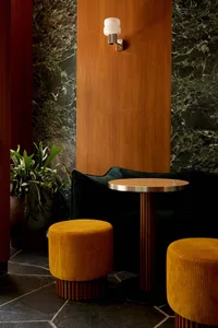 Metallic industrial-style restaurant seating area with a round table and stools.