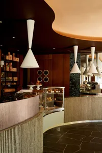 A modern restaurant interior featuring concrete and marble materials.