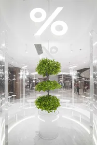 A modern shopping mall interior with minimalist design, featuring glass and concrete materials.