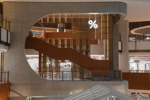 Industrial-style restaurant interior with metallic elements and large percentage symbol.
