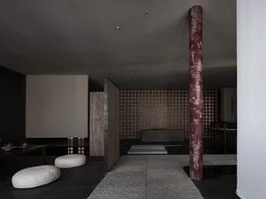 Modern minimalist living room with concrete and wooden elements.