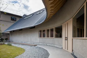 Modern metallic-clad building with curved roof and wood accents.