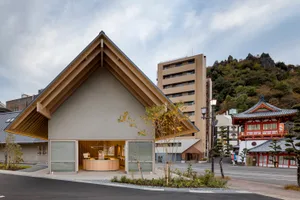 A modern public space featuring mixed materials with a prominent building facade and surrounding landscape.