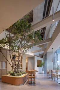 Modern industrial restaurant interior featuring wood materials and greenery.