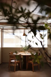 A cozy modern restaurant interior with wooden furniture and a round table.