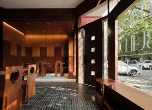 A modern coffee shop interior featuring wooden furniture and minimalist design.