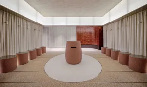 Modern spa bathroom interior with round, terracotta-ceramic feature piece surrounded by white curtains and circular seating a