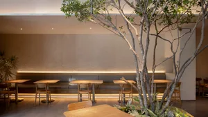 Modern wooden interior design of a coffee shop with seating and tables.