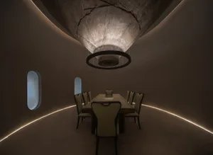 Industrial-style dining room with concrete ceiling and lighting, featuring a rectangular table and six chairs.
