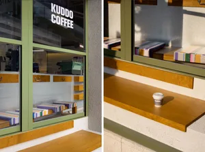 An exterior view of a coffee shop with a wooden sill, showing the branding and window seats.