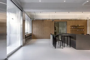 Industrial-style coffee shop with white flooring and wooden seating.