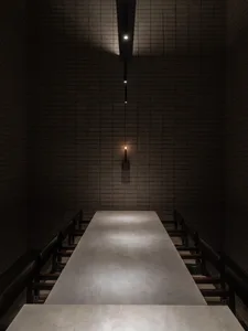 A modern corridor with a concrete floor viewed from a perpendicular angle.