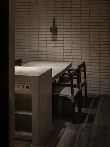 A minimalist kitchen with concrete countertops and walls.