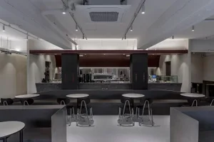 An industrial-style cafe with a metal bar counter and white counter tops.