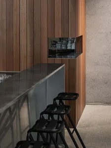 A modern bar with a metal countertop and wooden cabinets