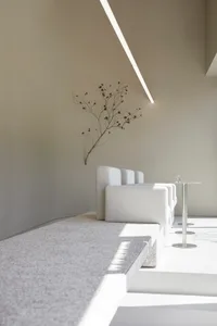 Minimalist waiting area with terrazzo flooring and white furniture.