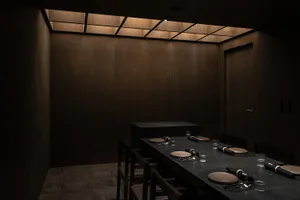 A modern private dining room with wood paneling and a large table.